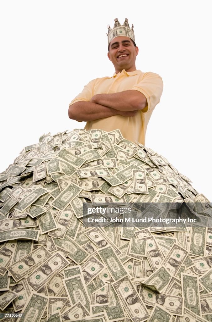 Hispanic man standing in pile of money