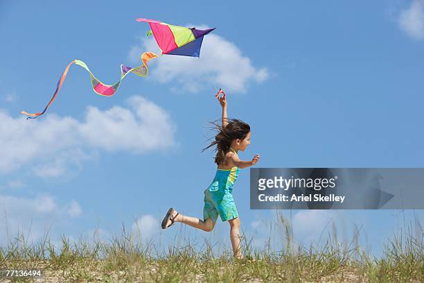 hispanic girl flying kite - vlieger stockfoto's en -beelden
