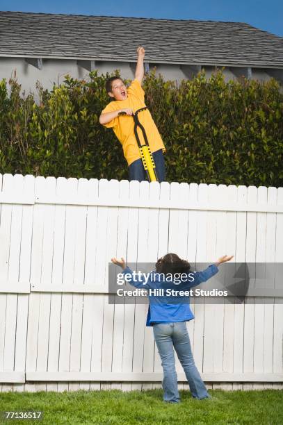 mixed race boy trying to jump fence with pogo stick - pogo stick stock pictures, royalty-free photos & images