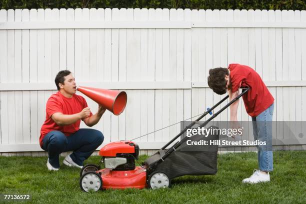 hispanic father yelling at son mowing lawn - coach cheering stock pictures, royalty-free photos & images