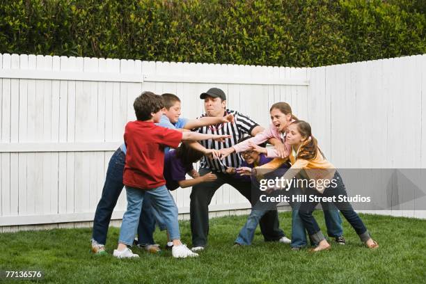 hispanic referee between groups of boys and girls - conflict resolution stock-fotos und bilder
