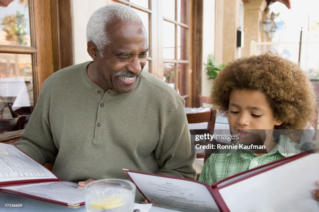 African American grandfather and grandson at restaurant