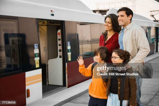 hispanic family at train station - waving goodbye train photos et images de collection