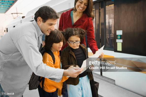 hispanic family looking at map - lost generation stock pictures, royalty-free photos & images