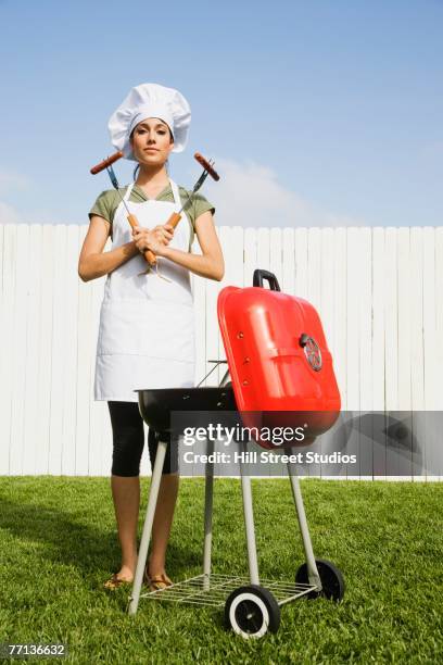 hispanic woman barbecuing - tablier photos et images de collection