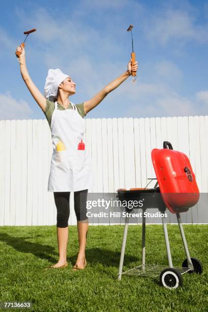 hispanic woman barbecuing - apron woman photos et images de collection