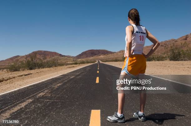 mixed race female runner on road - forward athlete stock pictures, royalty-free photos & images