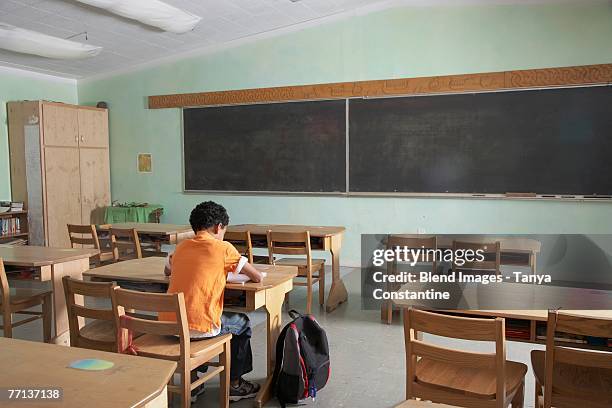 mixed race boy in empty classroom - punição imagens e fotografias de stock