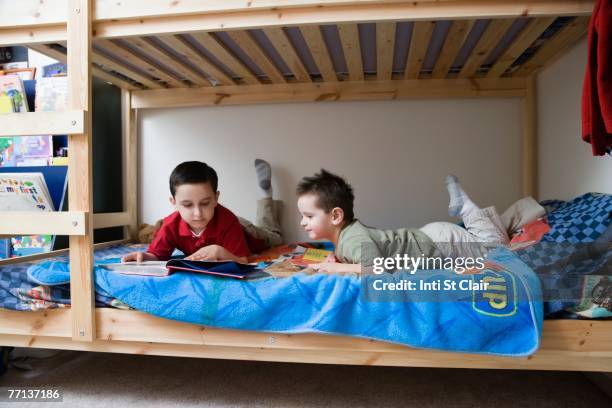 hispanic brothers reading in bed - bunk beds for 3 stock-fotos und bilder