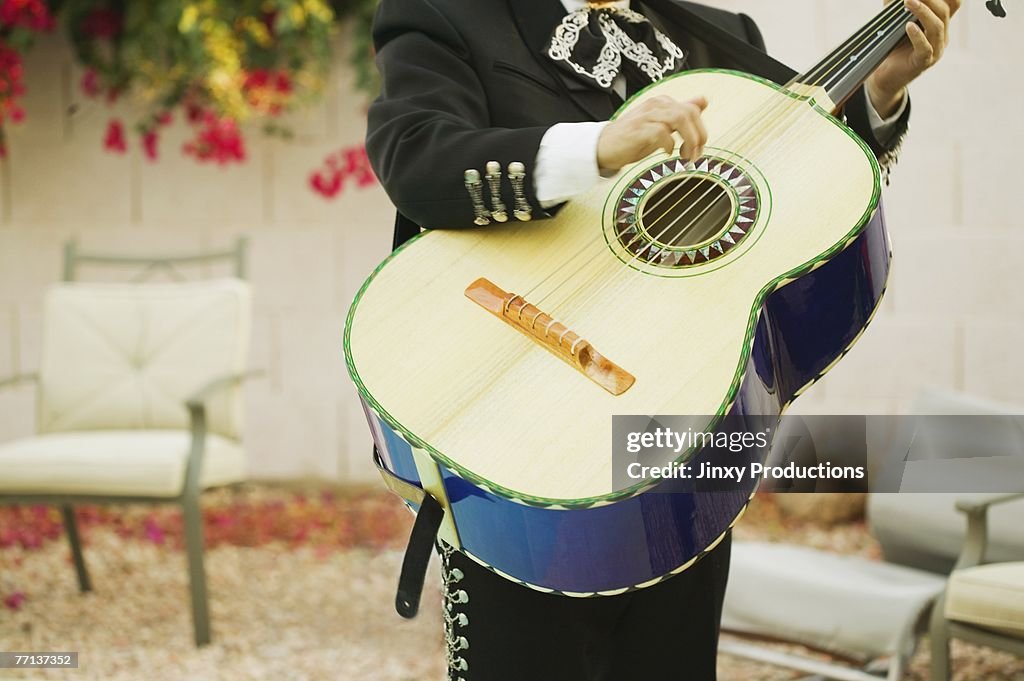 Mariachi band member holding guitar