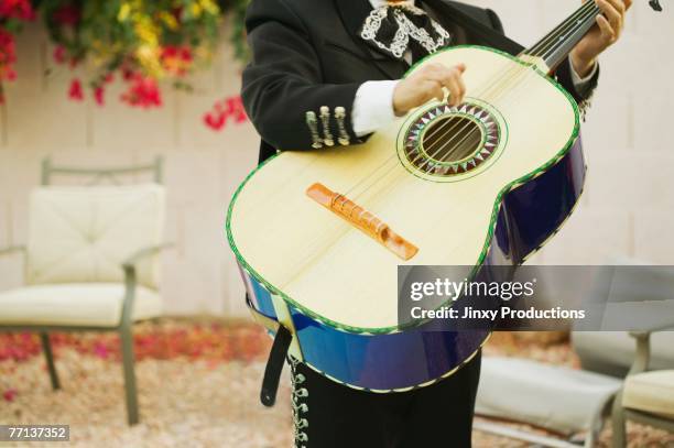 mariachi band member holding guitar - mariachi fotografías e imágenes de stock