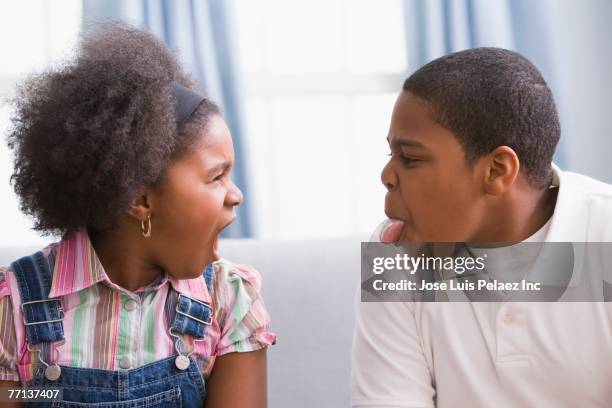 african american brother and sister making faces - geschwister frech stock-fotos und bilder