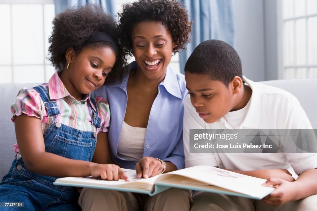 African American mother and children looking at photo album
