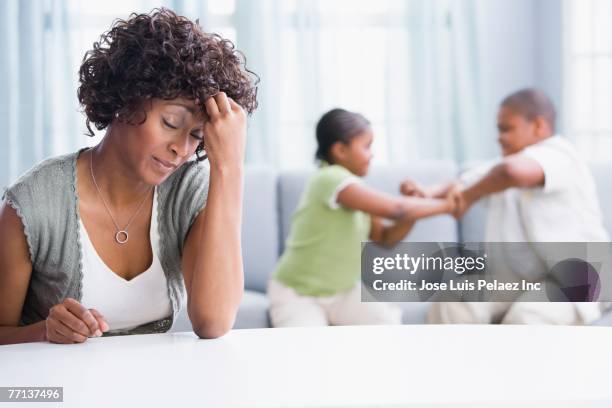 frustrated african american mother with children fighting - children fighting stock pictures, royalty-free photos & images