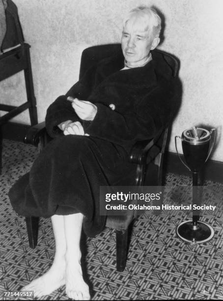 Photograph of American poet Carl Sandburg lounging in his bathrobe at the Skirvin Hotel in downtown Oklahoma City, Oklahoma, February 11, 1938.