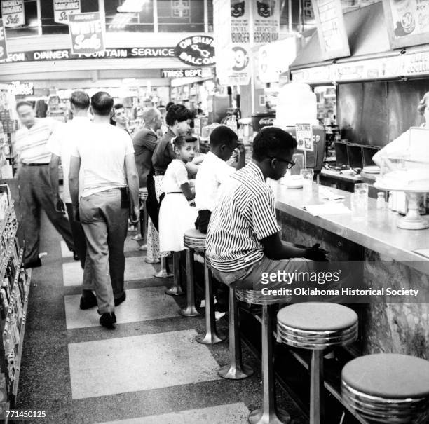Photograph of a Civil Rights sit-in led by Clara Luper to desegregate the lunch counter at Katz Drug Store at Main and Robinson in downtown Oklahoma...