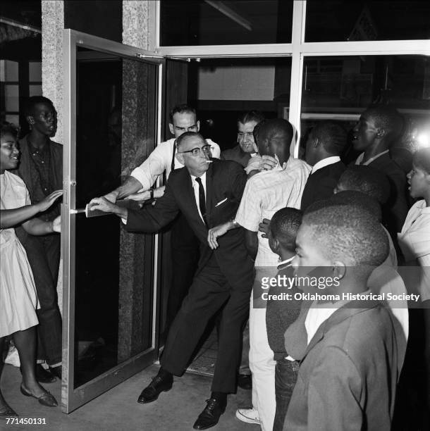 An unidentified man bars a group of African-American children and young adults from entering Bishop's Restaurant at 113 North Broadway in downtown...