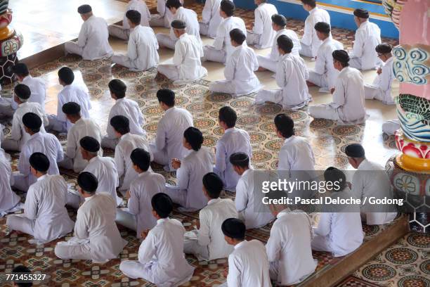 cao dai holy see temple. praying devout men, ceremonial midday prayer. thay ninh. vietnam.  - cult stock pictures, royalty-free photos & images