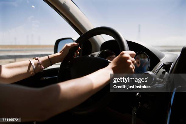 woman driving through the desert - hands steering wheel stock pictures, royalty-free photos & images