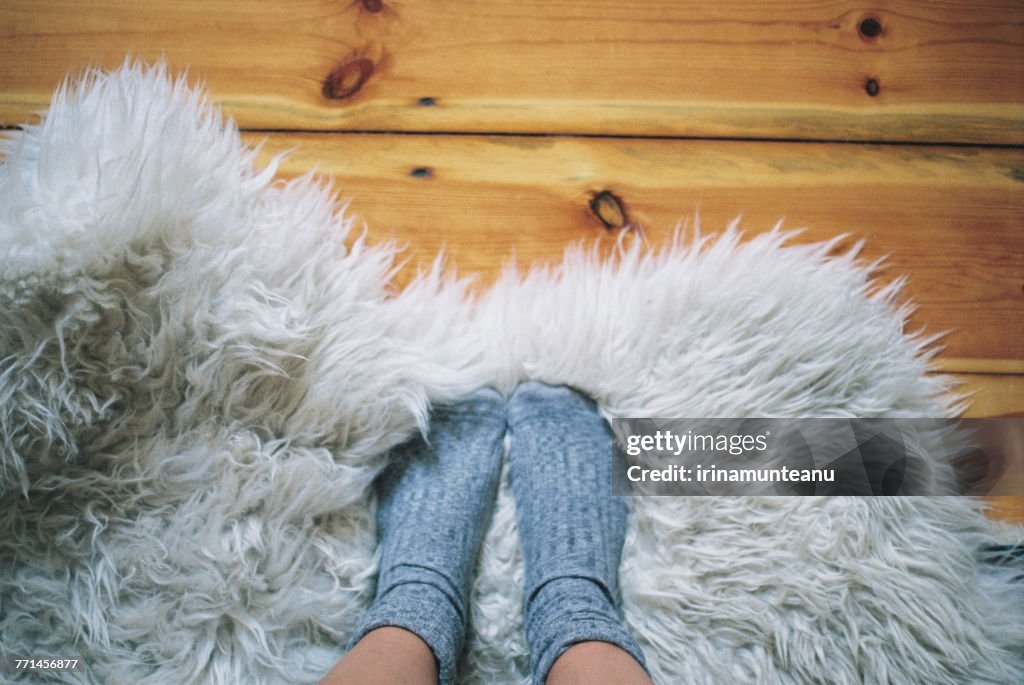 Womans feet wearing socks on a rug