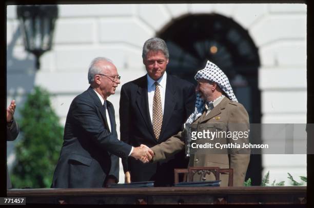Yasir Arafat and Israeli Prime Minister Yitzhak Rabin shake hands September 13, 1993 in Washington, DC. The political leaders attended the signing of...
