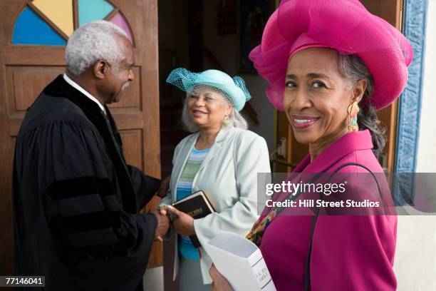 senior african women talking to reverend - african american church stock-fotos und bilder