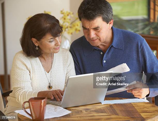 senior hispanic couple paying bills - budget reconciliation stock pictures, royalty-free photos & images