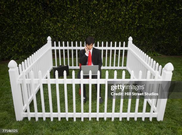 asian businessman surrounded by fence - surrounding stock pictures, royalty-free photos & images