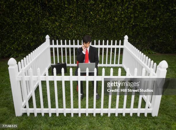 asian businessman surrounded by fence - rodeando - fotografias e filmes do acervo