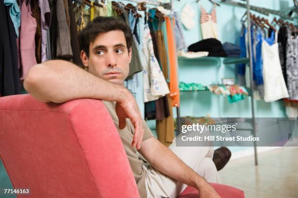 hispanic man waiting in clothing store - shopping male foto e immagini stock