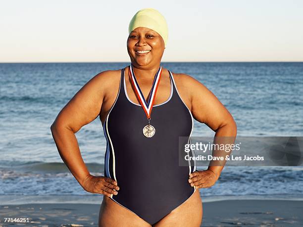 mixed race woman with medal on beach - chubby swimsuit stock pictures, royalty-free photos & images