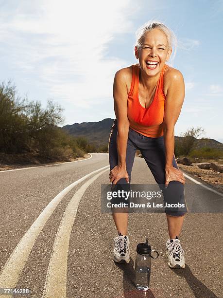 senior hispanic woman taking break from jogging - woman standing exercise stock pictures, royalty-free photos & images