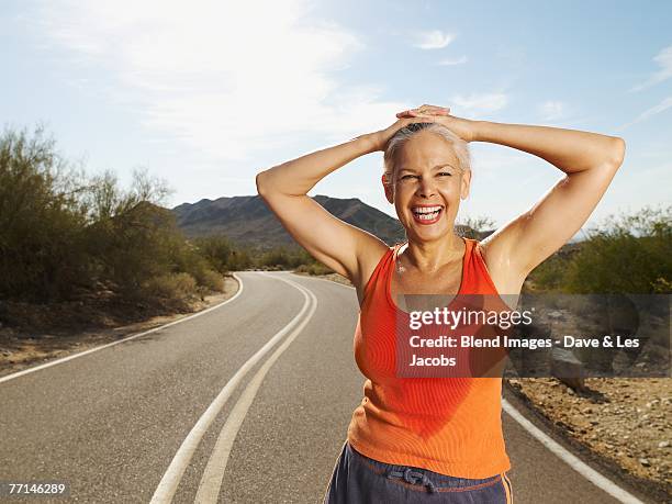 senior hispanic woman taking break from jogging - woman standing exercise stock pictures, royalty-free photos & images