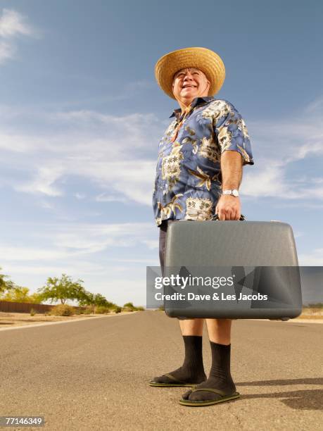 senior mixed race man holding suitcase - lost sock stock pictures, royalty-free photos & images