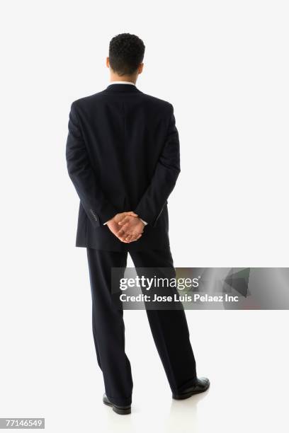 hispanic businessman with hands behind back - vista posterior fotografías e imágenes de stock