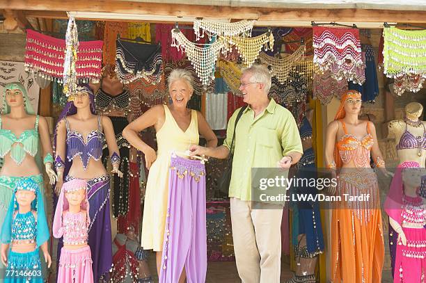 senior couple looking at belly dancing outfits - belly dancing stock pictures, royalty-free photos & images