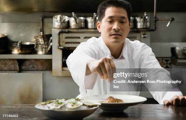 asian male chef seasoning food - japanese fat man bildbanksfoton och bilder