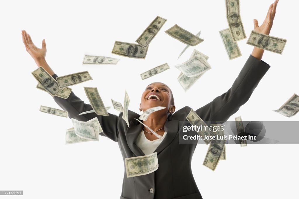 African American businesswoman throwing money in the air