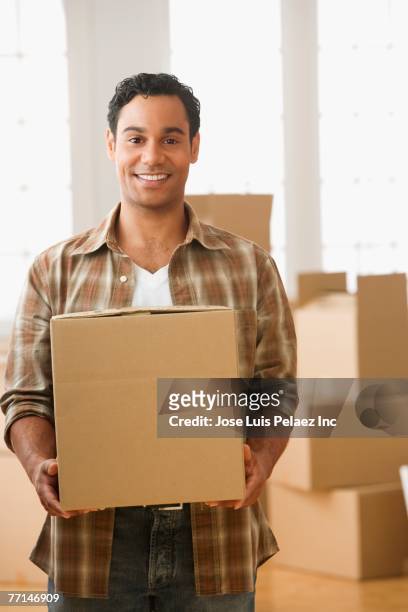 hispanic man carrying moving box - solo un uomo di età media foto e immagini stock