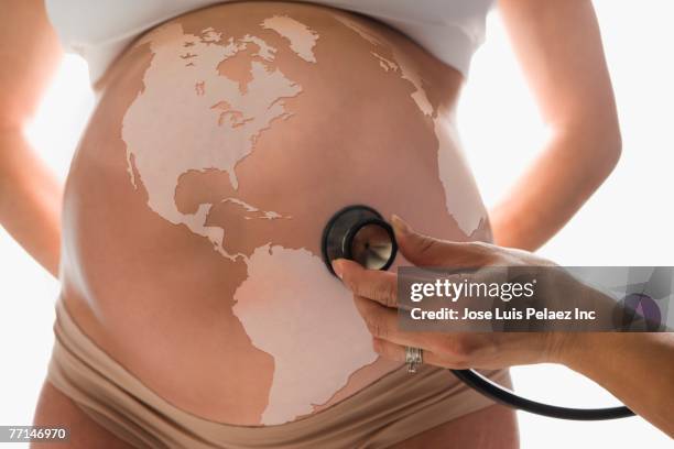 pregnant hispanic woman with globe on belly - esplosione demografica foto e immagini stock