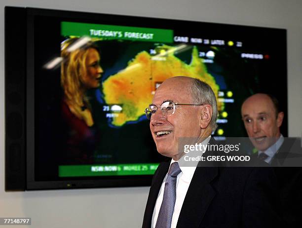 Australian Prime Minister John Howard followed by Optus CEO Paul O'Sullivan , tours the new Optus national headquarters near Sydney, 02 October 2007....