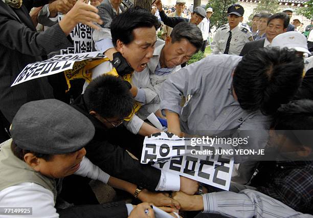South Korean protesters scuffle with plainclothes policemen as police seize a North Korean flag during an anti-North Korea rally at a park in Seoul,...