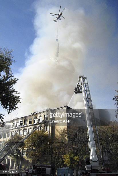 Fire-brigade helicopter dumps water on the burning dormitory of the Moscow Institute of State and Corporate Governance in the Russian capital, 02...