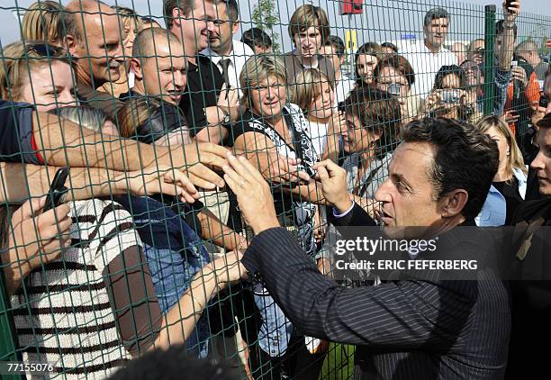 Le Pr?sident Nicolas Sarkozy sert les mains de personnes apr?s une visite de la Soci?t? dijonaise d'assistance par le travail qui emploie entre 160...