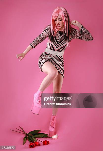 angry woman stomping on tulips with her platform boots - platform shoe stockfoto's en -beelden