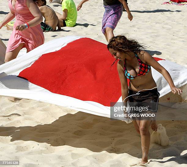 Young Wilderness Society member helps lay out giant letters on Sydney's Bondi Beach, 03 October 2007, asking the federal government to stop the...