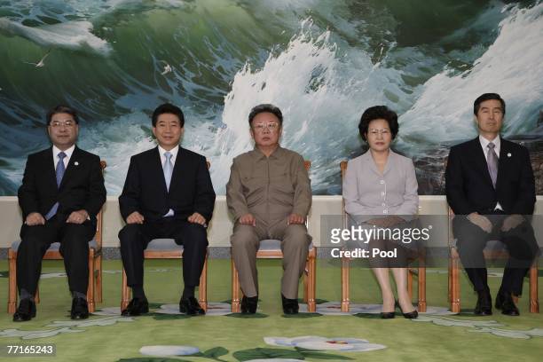 South Korean President Roh Moo-Hyun his wife Kwon Yang-Sook pose with North Korean leader Kim Jong-Il as other South Korean delegations sit during...