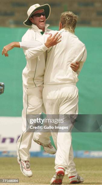 De Villiers and Paul Harris of South Africa celebrate the wicket of Salman Butt during day three of the first test match between Pakistan and South...