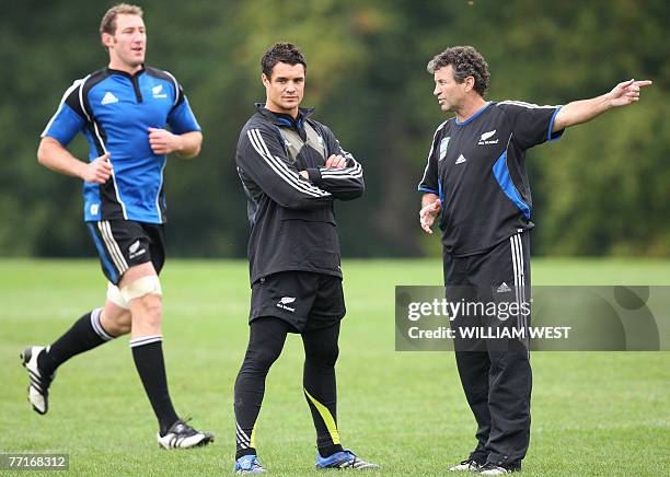 New Zealand All Black flyhalf Daniel Carter chats to assistant coach Wayne Smith as Carter recovers from an injury while lock Chris Jack jogs pass...