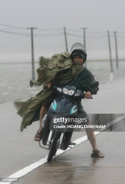 Motorcyclist fights against strong wind as he drives on national highway No 1 in the central province of Ha Tinh 03 October 2007 as tropical typhoon...
